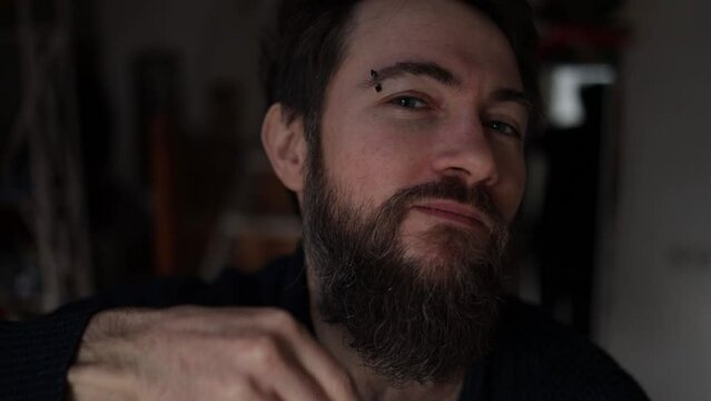 stylish serious man with handsome beard. Bearded man comb his beard.