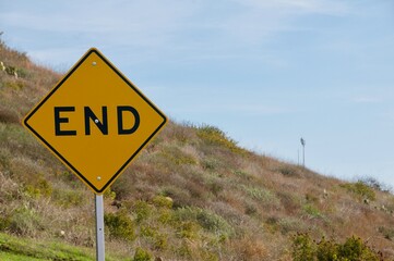 End of road traffic sign yellow black blue sky