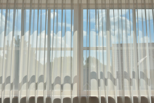 Sky showing behind curtain on window, Germany