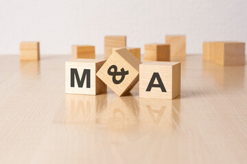 MA - an abbreviation of wooden blocks with letters on a gray background. reflection caption on the...