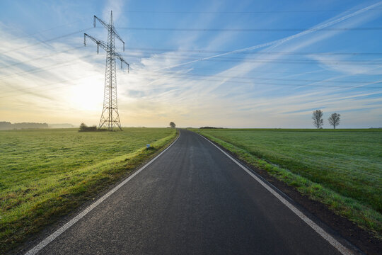 Country Road with Electricity Pylon in Morning with Sun, Freiensteinau, Vogelsbergkreis, Hesse, Germany