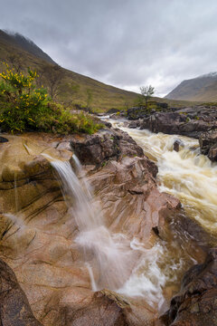 Waterfall on River Coupal with overcast sky at Glen Coe in Scotland, United Kingdom