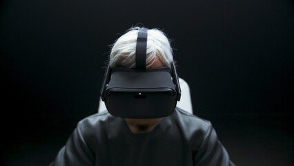 Involved man starting vr headset experience dark room. Player prepare for game