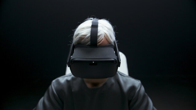 Involved man starting vr headset experience dark room. Player prepare for game