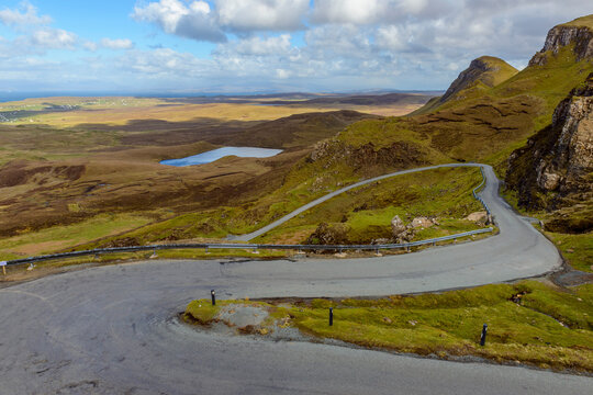 Hilly landscape with winding mountain pass road on the Isle of Skye in Scotland, United Kingdom