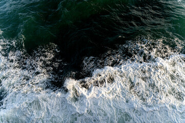 Looking down from the bow of a ferry at water foaming and forming waves