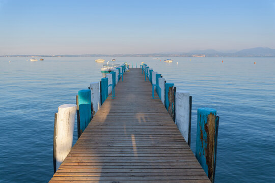 Wooden jetty on Lake Garda (Lago di Garda) in the morning at Bardolino in Veneto, Italy