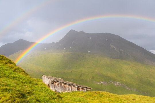 Rainbow over mountain landscape with mountain hut at Kaiser Franz Josefs Hohe in Grossglockner High Alpine Road in the Hohe Tauern National Park, Carinthia, Austria