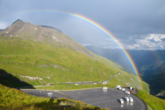 Rainbow over mountain landscape with car park at Kaiser Franz Josefs Hohe in Grossglockner High Alpine Road in the Hohe Tauern National Park, Carinthia, Austria