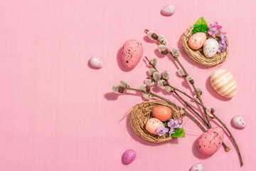 Obraz na płótnie Canvas Traditional Easter composition - eggs, bird's nests, willow twigs, themed decor. Pink background