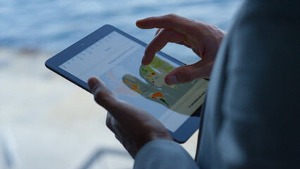Manager hands swiping tablet at sea landscape closeup. Boss analyzing charts