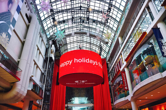 Toronto, Canada - December 21, 2022: Happy holidays greeting on giant LED screen with Christmas and new year decoration at Eaton Centre mall.