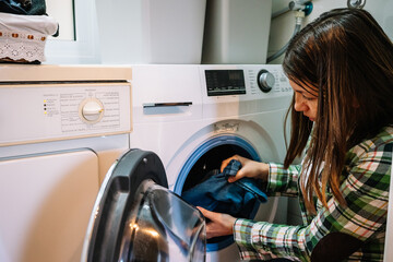 woman puts washing machine at home
