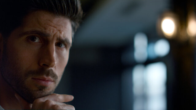 Businessman thinking in dark cafe portrait. Pensive man face expression closeup
