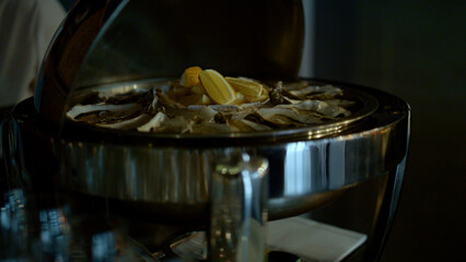 Delicious oysters and lemon serving on iced plate closeup. Luxury dinner concept