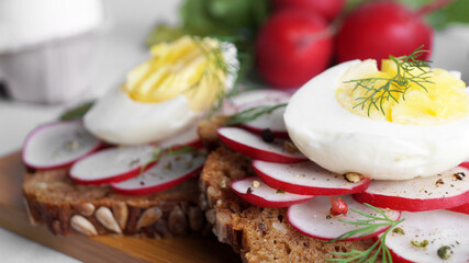 Tasty sandwiches with boiled egg and radish on table, closeup