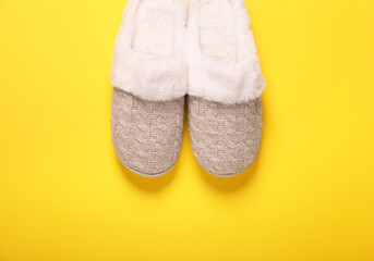 Pair of beautiful soft slippers on yellow background, top view