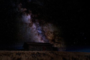 Naklejka na ściany i meble Milky way over an abandoned cabin in the desert