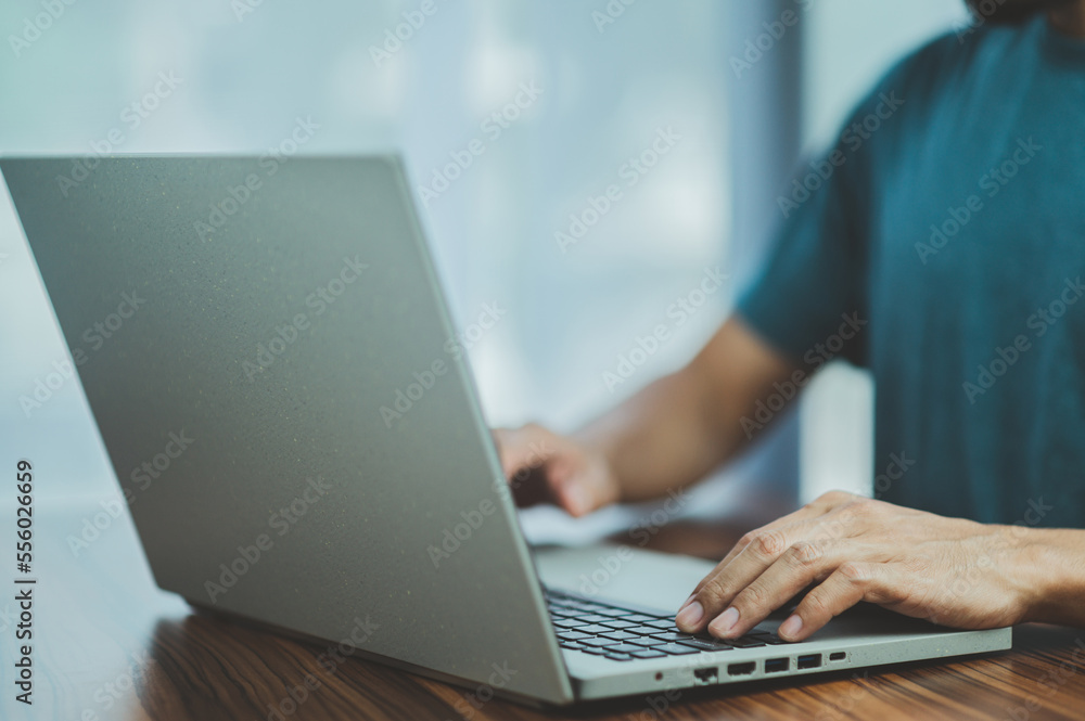 Poster people using computer side view of male hands typing on laptop keyboard