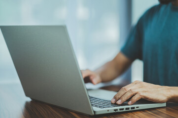 Fototapeta premium People using computer Side view of male hands typing on laptop keyboard