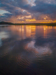 Sunrise over the bay with clouds and reflections