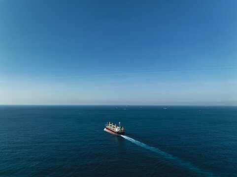 Aerial view of a cargo ship on the move in the middle of the sea