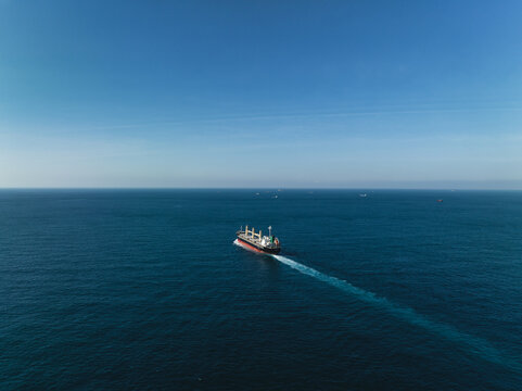 Aerial view of a cargo ship on the move in the middle of the sea