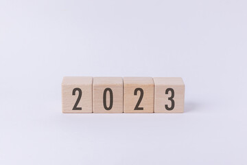 Flipping wood cube block from 2022 to 2023 text isolated in white background. New year goal, action plan, business plan, finance and marketing strategy concept.