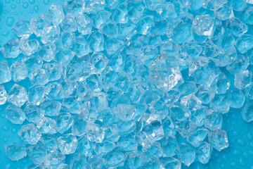 Obraz premium Ice cubes and ice shards with water drops on a blue background. The concept of cold and freshness