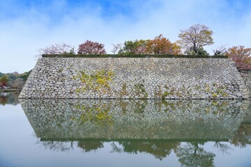 青空バックに見るお城の石垣とカラフルな紅葉のコラボ情景＠兵庫