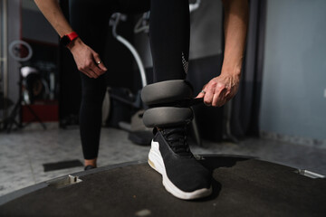 close up on hand of woman putting on adjustable ankle weight indoor