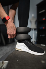 close up on hand of woman putting on adjustable ankle weight indoor