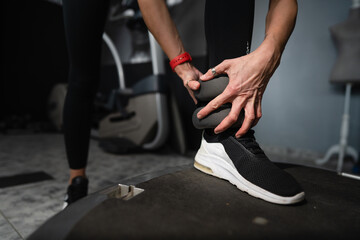 close up on hand of woman putting on adjustable ankle weight indoor