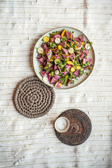 flatlay food photo of colorful fresh salad on yellow and white textile mat