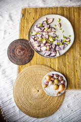 Yellow handwoven textured mat with radishes, onions, potatoes, and peppers - healthy vegan and vegetarian lifestyle food styling