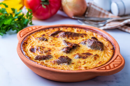 Tave kosi is a national Albanian dish of baked lamb and rice with yoghurt close-up in a pan on the table. horizontal top view from above. Turkish name; Elbasan tava