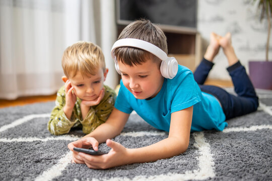 Two children watching smart phone, happy kids using smartphones together