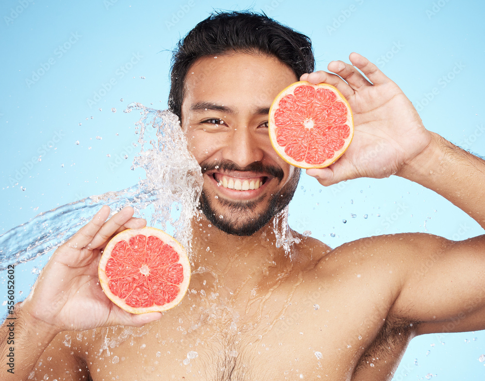 Sticker face, water and grapefruit with a man model in studio on a blue background for hygiene or natural hy