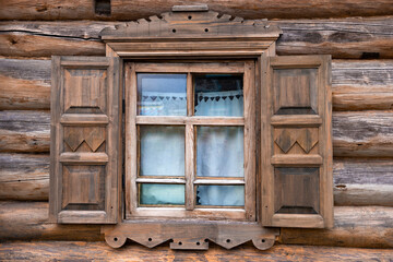 Window with shutters of an old wooden house close-up. Leningrad region, Verkhniye Mandrogi. Russia