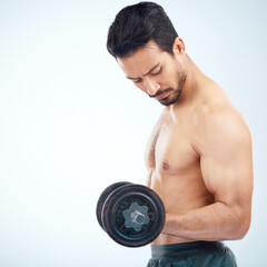 Man, fitness and dumbbell in studio for muscle, wellness and self care on blue background with focus. Model, bodybuilder workout and training for health, body or development with exercise on backdrop