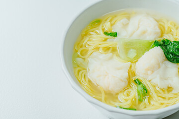 Chinese cuisine shrimp wonton dumpling noodle soup food in white bowl on white table background
