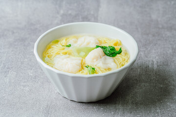 Chinese cuisine shrimp wonton dumpling noodle soup food in white bowl on white table background