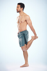 Fototapeta premium Fitness, health and man stretching leg in studio isolated on a blue background mock up. Sports, body wellness and young male athlete stretch, warm up and preparing for workout, exercise and training.