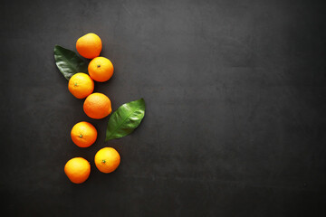 Citrus fruits on a gray background. Tangerines with leaves. Christmas fruit.