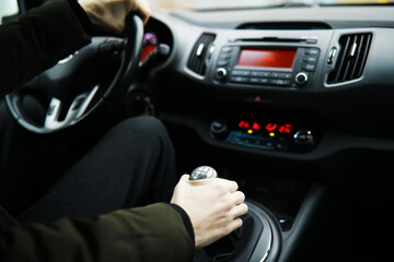 Hand on the car gear knob. The driver switches the speed in the car. Hand on gear lever.