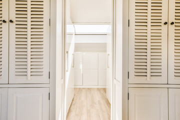 the inside of a house with shutters on the doors and wood flooring in the hallway leading to...