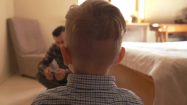 the father is playing with the boy in the constructor. father plays with his son in the constructor. the boy is playing in the constructor