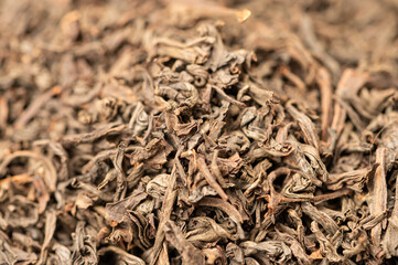 Large-leaved black tea in bulk on the table. Close-up of the surface texture