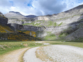 Winding road that goes towards the mountains and where a storm is coming