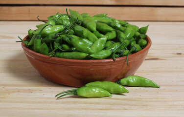 Bowl of Fresh Green Aji Limo Chili Peppers on Wooden Table